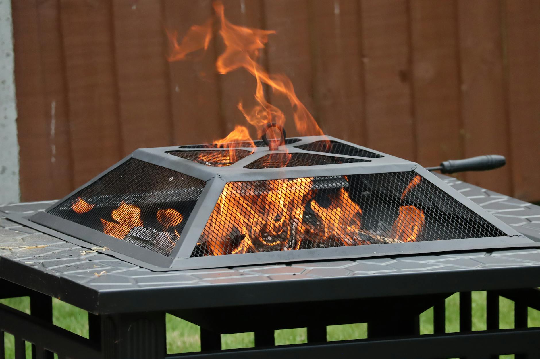 A blazing fire pit with rising flames set in an outdoor area, captured in Norwich, UK.
